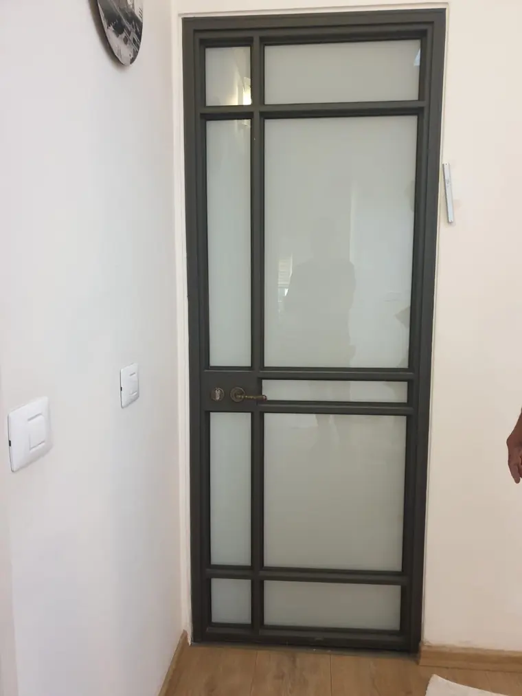 דלת פנים אלומיניום בפרופיל שחור עם זכוכית חלבית