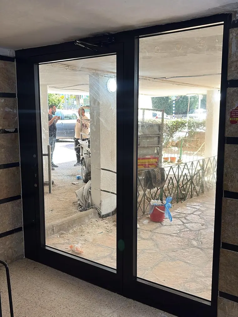 מערכת הזזה מזוגגת בפרופיל שחור בכניסה לבית